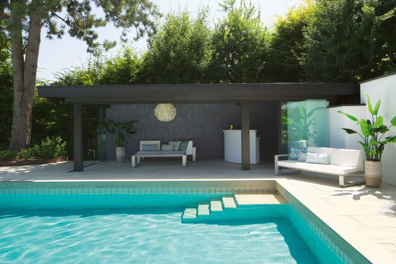 Die Platten führen von der Küche über den Wohnbereich bis hin zum Pool und verbinden die Bereiche geschickt miteinander. Das Poolhaus dient nun als überdachter Sitzplatz.