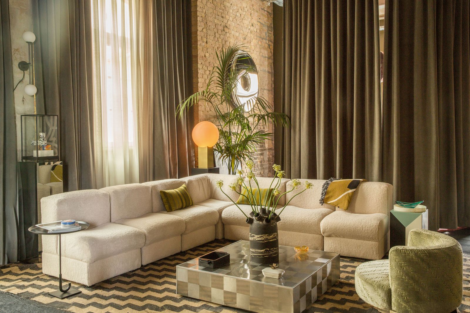 Ein Setting, das nicht langweilig wird: Das Wohnzimmer strahlt die lockere Lebensfreude der Siebziger aus, der skulpturale Spiegel von Oskar Zieta und der Couchtisch mit den Edelstahlquadraten sorgen für Discofeeling. Letzterer ist ein Original aus Italien von Willy Rizzo. Sofa und Sessel sind Vintage-Stücke aus Spanien, die Fabian Freytag neu polstern liess. Den Beistelltisch mit dem Schirmfuss hat der Designer selbst entworfen.