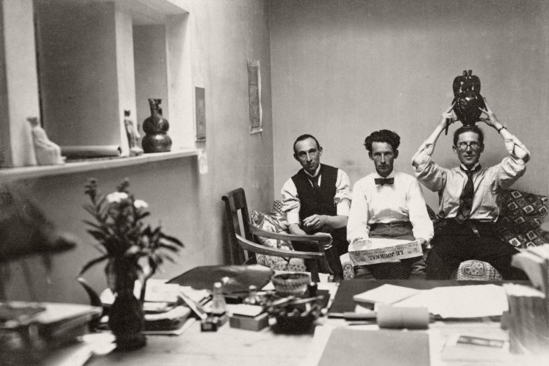 Le Corbusier, mit serbischer Vase auf dem Kopf, zusammen mit Albert Jeanneret und Amédée Ozenfant in der Maison Blanche, La Chaux-de-Fonds, August 1919.