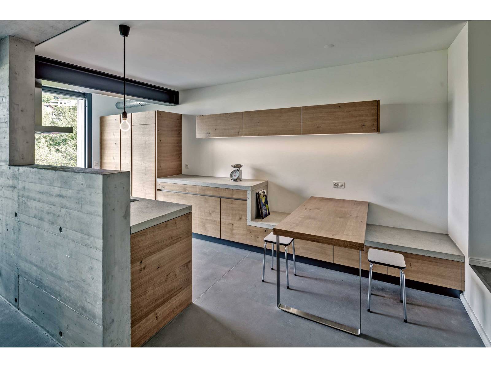 Die moderne Betonküche setzt ganz auf geometrische Formen und eine reduzierte Materialisierung. Sie ist ein Teil der Architektur, wirkt trennend und ist doch in den Wohnraum integriert. Beton und Holz bilden eine stimmige Kombination und sorgen für eine angesagte, monochrome Optik. BRUNNER-KUECHEN.