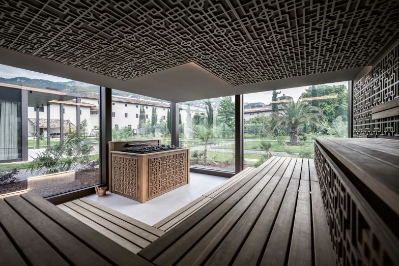 Die Sauna mit ihren schönen Holzreliefs, in denen der Granatapfel wieder auftaucht, bietet einen grandiosen Ausblick auf den Klostergarten. Durch eine spezielle Verspiegelung des Glases kann man jedoch nicht hineinsehen.