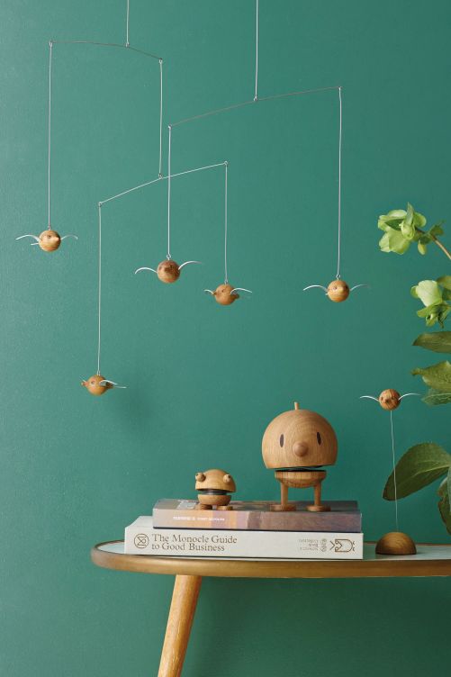 «Birdie» war einer der ersten Hoptimisten, im Original jedoch aus Kunststoff gefertigt. Ohne vom strikten Grundprinzip des Erfinders abzuweichen, werden die Vögel nun intern weiterentwickelt: zum Beispiel in Form eines Mobiles mit «Woody Birdies» aus nachhaltig geschlagenem Eichenholz.