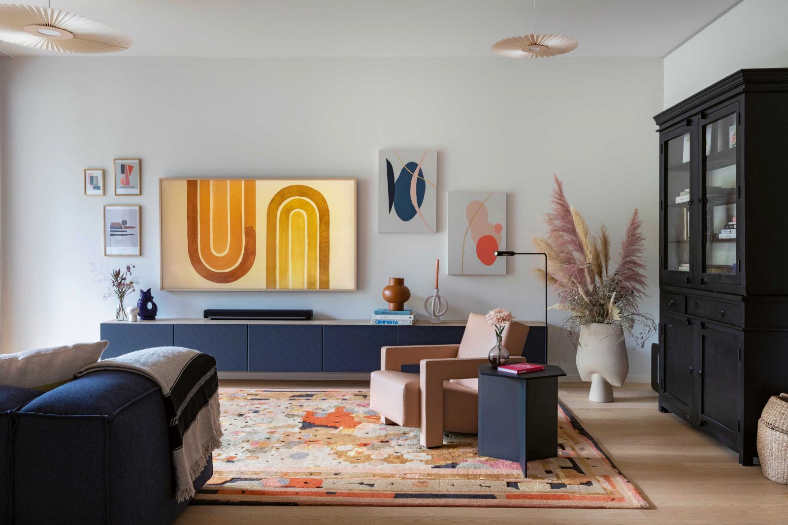 Das «i-Tüpfelchen» der Wohnung, den Teppich «Fantaisie Impromptu», entdeckten die Interior Designerinnen bei Reuber Henning. Die hellgrauen Wände bringen die farbenfrohen Möbel regelrecht zu Strahlen. Beistelltisch: Neo/Craft; Leuchte: Hartô; Sessel: Cassina; Kunst: Nina-Sophie Gekele.